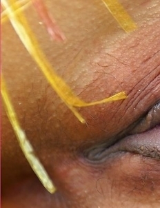 Jasmine Mookjai squats down and smiles at the camera. She shows how sexy she can be as she places her fingers close to her mouth.