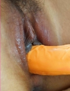 Jasmine Mookjai lies on her sofa in a maroon outfit. She starts to feel very kinky and she begins rubbing on her sexy body.