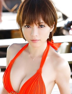 Japanese Yumiko Shaku  in orange bath suit takes a walk on the beach