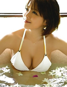 Japanese Yumiko Shaku  in orange bath suit takes a walk on the beach