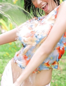 Chan Ching Ming picks up a hose and begins spraying herself with the hose.