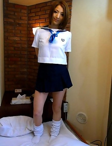 Reiko posing in her skimpy schoolgirl uniform before she strips down to suck a cock