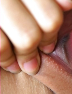 Dolla Dolaya lies on her stomach and gives that nice innocent smile.