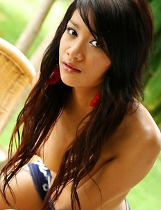 Lovely Benz Sarawadee is having an outdoor shooting and she is sitting on the wooden chair.