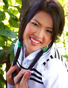 Aime Copony begins posing and she smiles for the camera while wearing a white and black top.