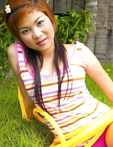 Amanda Wend is sitting on a green grass with a yellow pipe wrapped around her legs