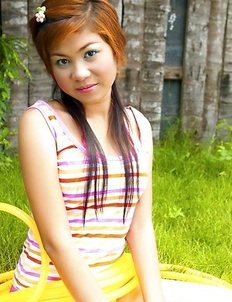 Amanda Wend is sitting on a green grass with a yellow pipe wrapped around her legs