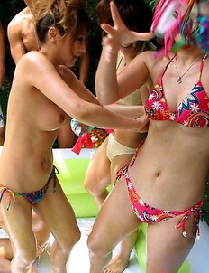 Asian teens wrestle by the pool