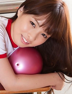 Maho Kiruma in sports equipment plays with ball on desk